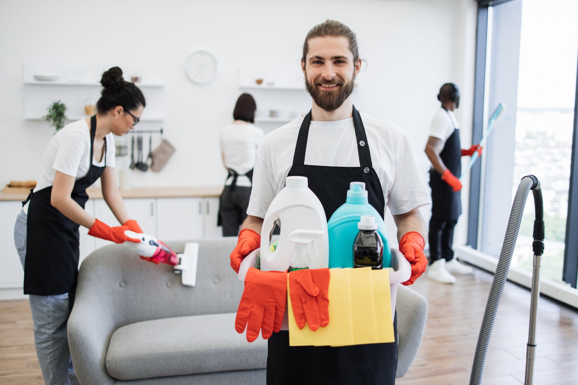 Portrait of bearded Caucasian man cleaning worker holding bucket with detergents